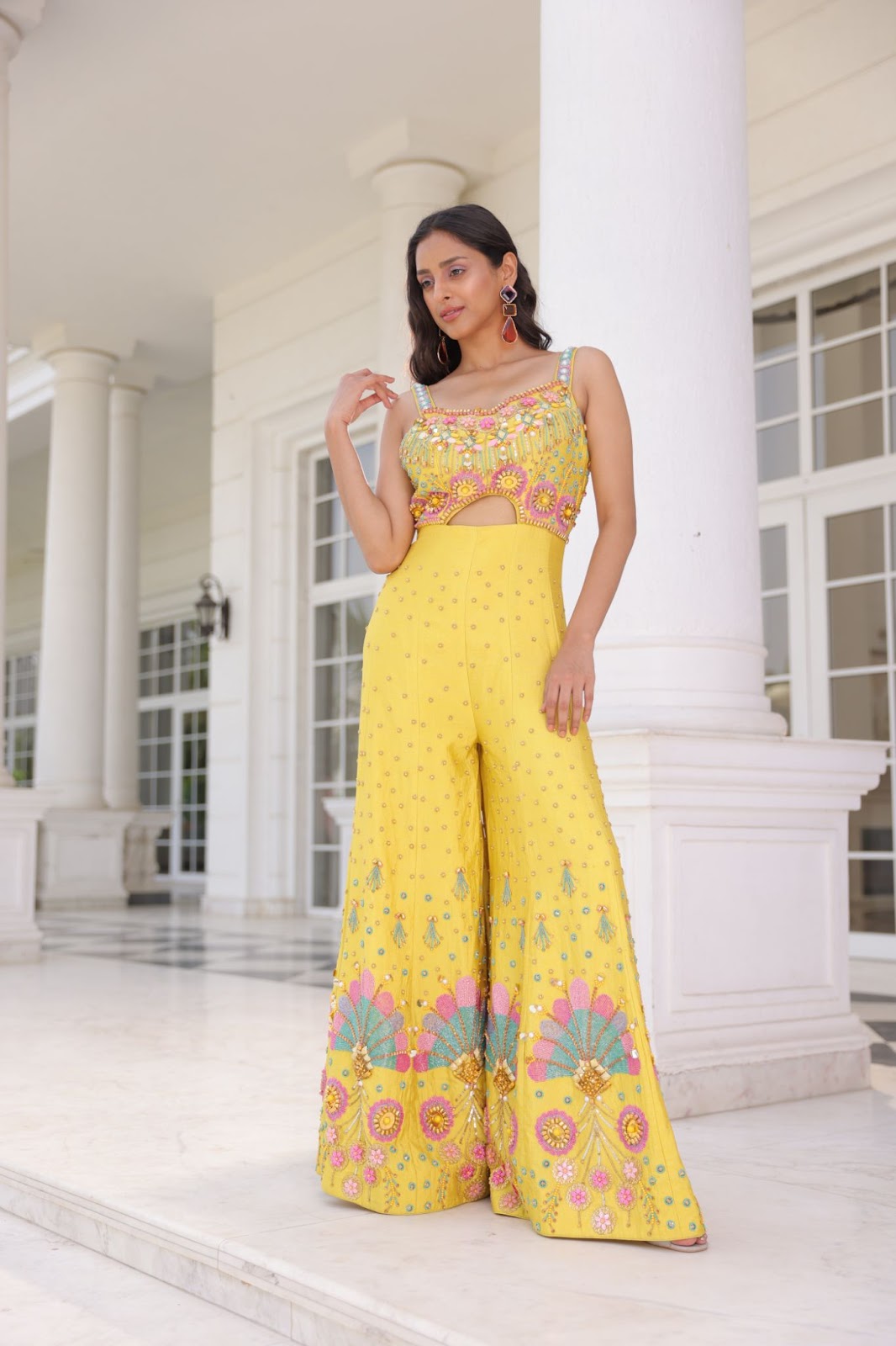 A model wearing yellow coloured palazzo fusion lehenga with modern bead work.